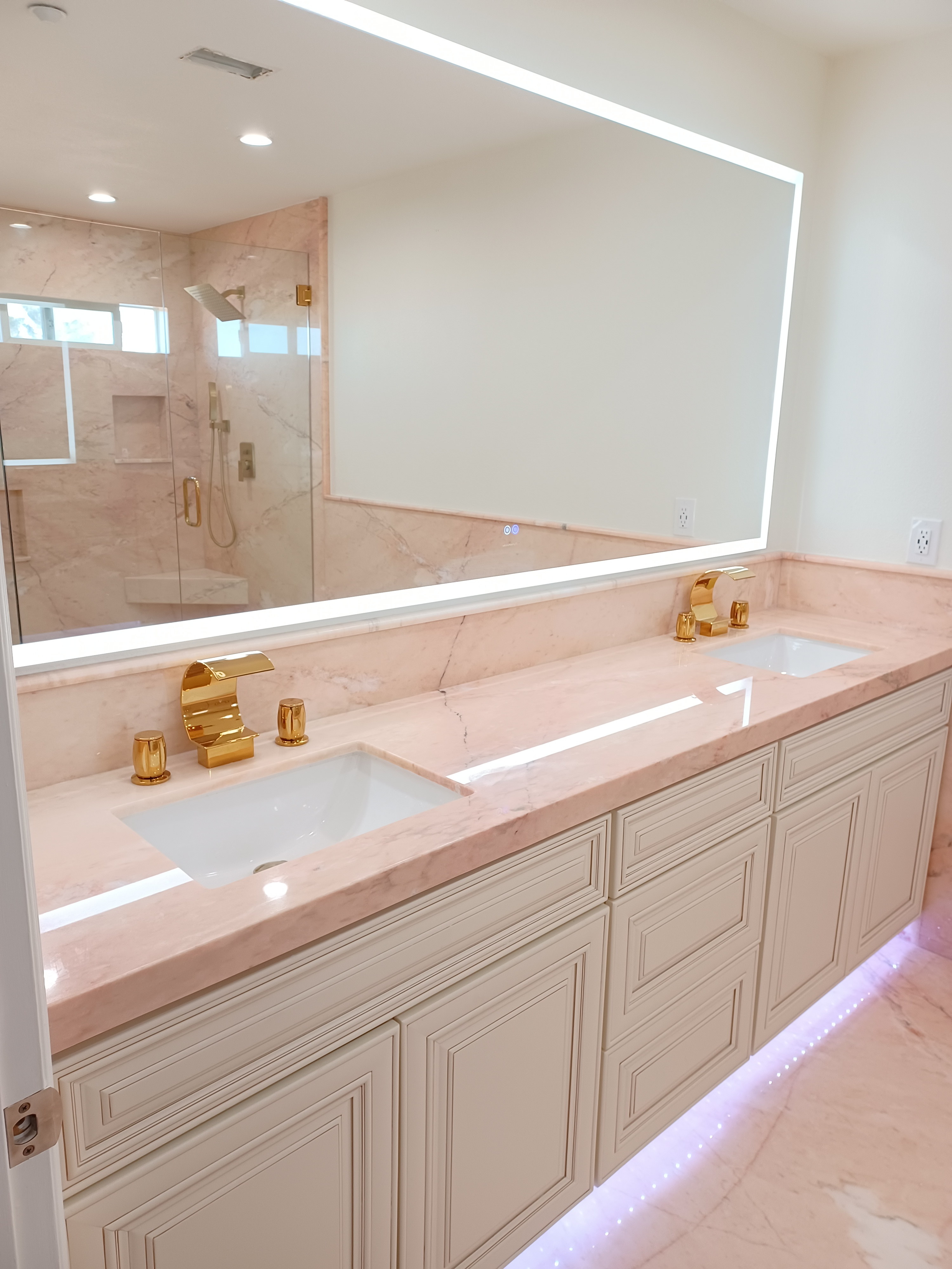 A bathroom with two sinks and a large mirror.